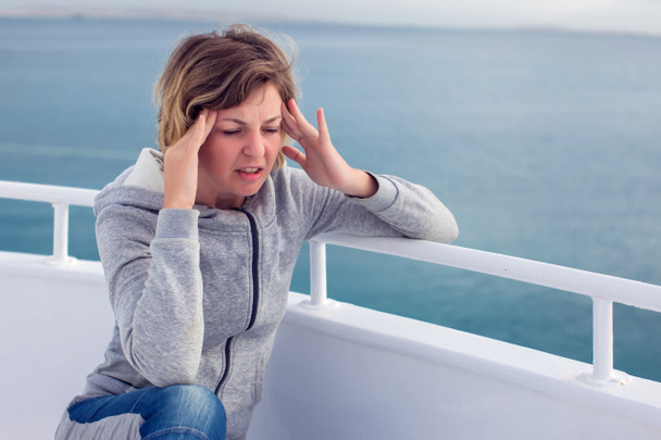 クルーズ海の乗り物酔いの観光客の女性は頭痛とボートの休暇に船酔い。クルーズ休暇中の旅行や病気のウイルスの恐怖. - 写真・画像