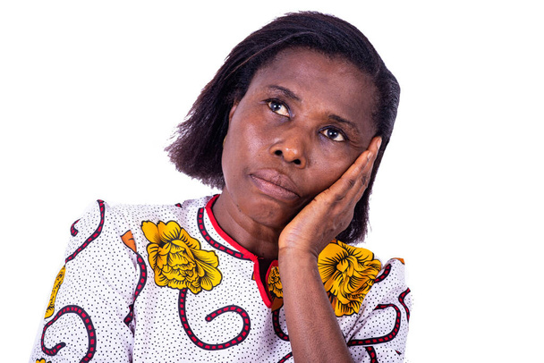 una mujer madura en un ramillete de pie sobre un fondo blanco pensando en problemas personales - Foto, Imagen