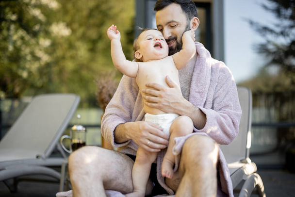 Apa egy egyéves kisfiúval a gyógyfürdőben pihen. - Fotó, kép