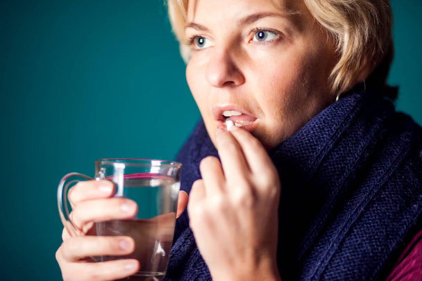 Woman with short blond hair got the flu and taking a pill. People, healthcare and medicine concept - Photo, Image