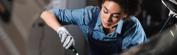 fiatal afro-amerikai szerelő dolgozik eszköz garázs, banner - Fotó, kép