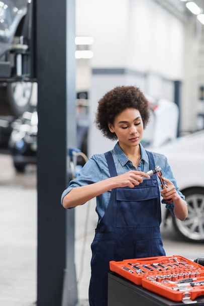 mladý africký americký mechanik držení zařízení v auto opravy garáže - Fotografie, Obrázek