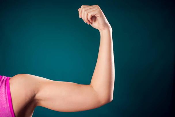 Woman with fit arm showing triceps and bicep. People, fitness and health concept - Foto, imagen