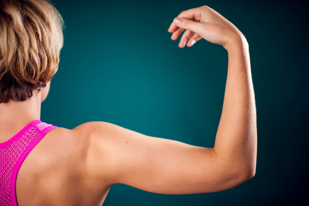 Woman with fit arm showing triceps and bicep. People, fitness and health concept - Foto, immagini