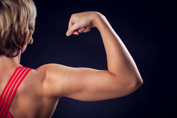 Woman in red top showing triceps and bicep. Fitness and health concept - Foto, Imagem