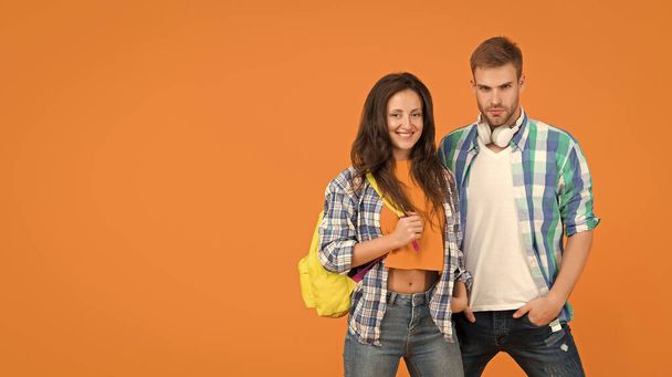 Romantic couple of serious handsome man and happy pretty woman in casual fashion style orange background, love, copy space - Photo, Image