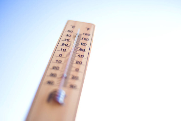 Thermometer auf dem blauen Himmelshintergrund. Wettervorhersage und Außentemperaturkonzept - Foto, Bild