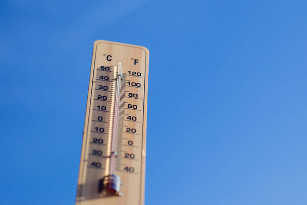 Thermometer on the blue sky background. Weather forecast and outdoor temperature concept - Valokuva, kuva
