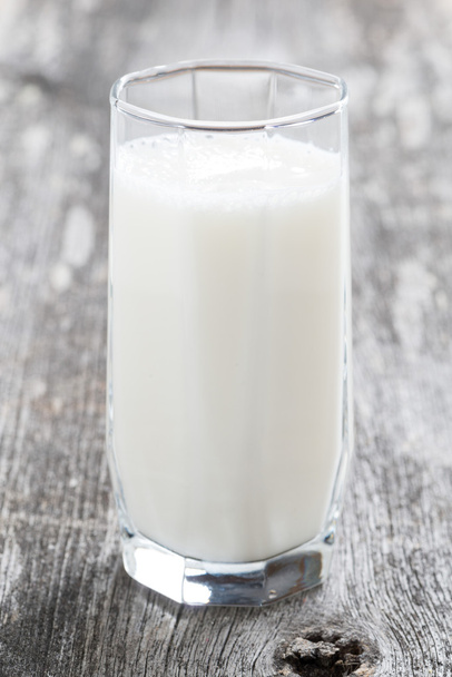 glass of milk or kefir on a wooden table - Foto, afbeelding