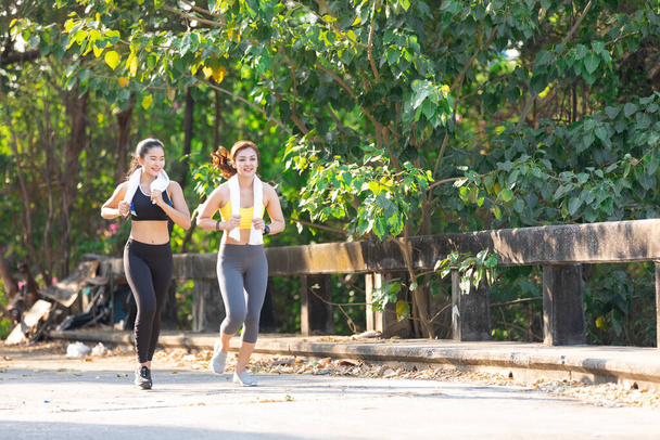 azjatycka lekkoatletyka para kobieta jogging i ćwiczenia razem w parku w godzinach wieczornych - Zdjęcie, obraz
