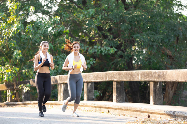Asijské atletika pár žena jogging a cvičení spolu ve veřejném parku ve večerních hodinách - Fotografie, Obrázek