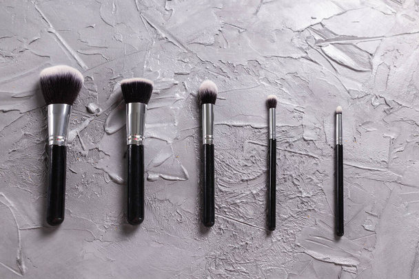 Top view of make-up brushes on grey background - Zdjęcie, obraz