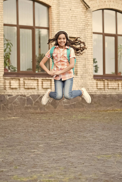 Szczęśliwej szkoły. Energiczny dzieciak skacze na zewnątrz. Wracać do szkoły. Edukacja szkolna. Szczęśliwej nauki. Prywatne nauczanie. Nauka w domu. Szczęśliwego międzynarodowego dnia dla dzieci - Zdjęcie, obraz