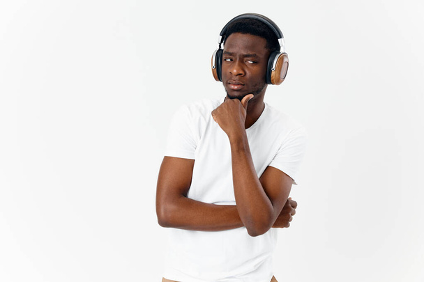 mies, jolla on tyytyväinen ilme kasvoillaan kuulokkeissa kuuntelee musiikkia  - Valokuva, kuva