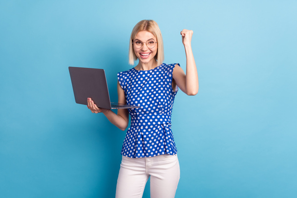 Photo of young attractive girl happy positive use laptop rejoice victory fists hand isolated over blue color background - Φωτογραφία, εικόνα