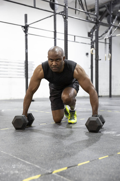 Jeune homme noir fort faisant de l'exercice de remise en forme dans la salle de gym. Espace pour le texte. - Photo, image