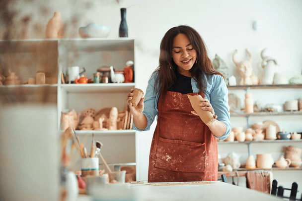 Belle femme joyeuse travaillant dans un atelier de poterie - Photo, image