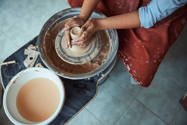 Mãos femininas jogando pote de barro na roda de cerâmica - Foto, Imagem