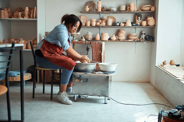 Charming young woman making pottery in workshop - Foto, Imagem