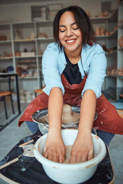 陶器を作った後に手を洗う陽気な女性陶芸家 - 写真・画像