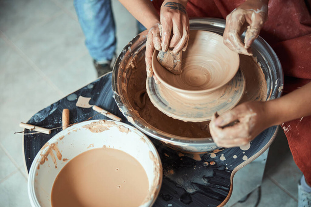 Potter hands polishing clay bowl in workshop - Photo, Image