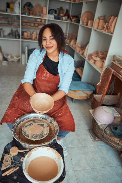 Beautiful young woman ceramist working in pottery workshop - Photo, Image