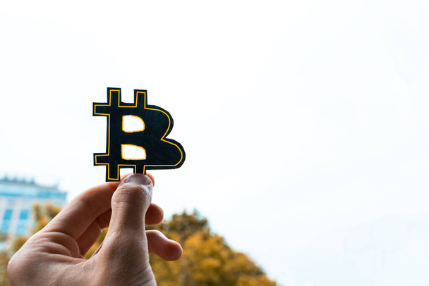 logo Bitcoin noir à la main. Bitcoin symbole à la main sur le fond de blanc sk - Photo, image