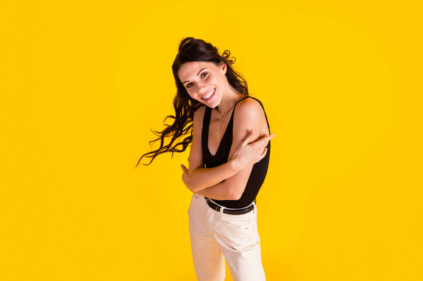 Top nad vysokým úhlem pohledu fotografie mladé dívky šťastný úsměv objetí sebe izolované přes žlutou barvu pozadí - Fotografie, Obrázek