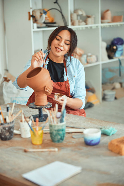Encantadora ceramista mujer pintura cerámica en el taller - Foto, imagen