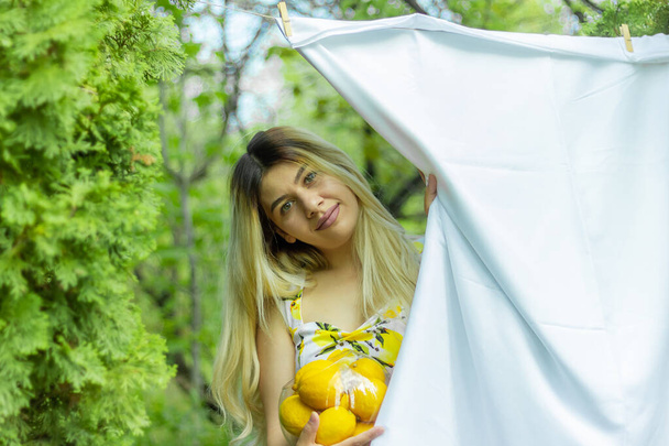 woman in the park, pretty woman with lemons in the park - Fotó, kép
