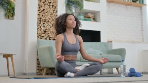 Fiatal afrikai nő otthon meditál a jóga matracon - Felvétel, videó