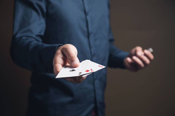 man holding playing cards on brown background - Photo, Image