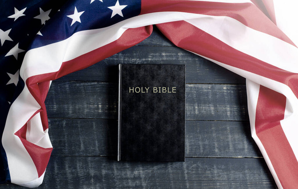 Drapeau des États-Unis. Livre biblique noir sur fond en bois. Constitution. - Photo, image