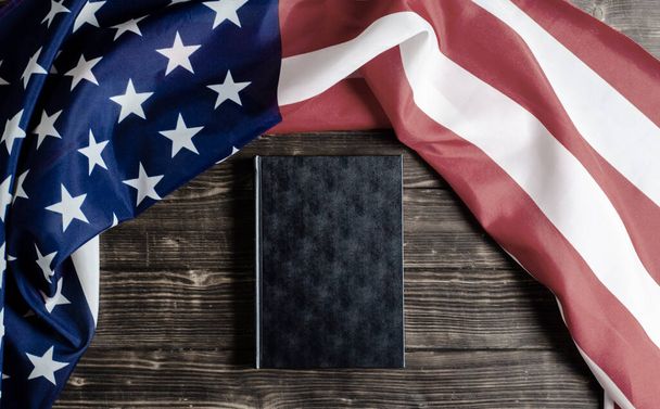 Amerikai Egyesült Államok zászlaja. Fekete könyv fából készült háttérrel. Alkotmány. A demokrácia garantálása. - Fotó, kép