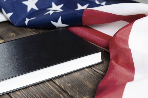 Amerikai Egyesült Államok zászlaja. Fekete könyv fából készült háttérrel. Alkotmány. A demokrácia garantálása. - Fotó, kép