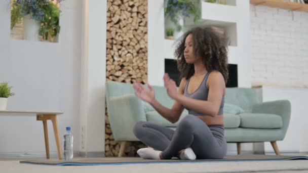 Мирная молодая африканская женщина медитирует на коврике для йоги дома - Кадры, видео