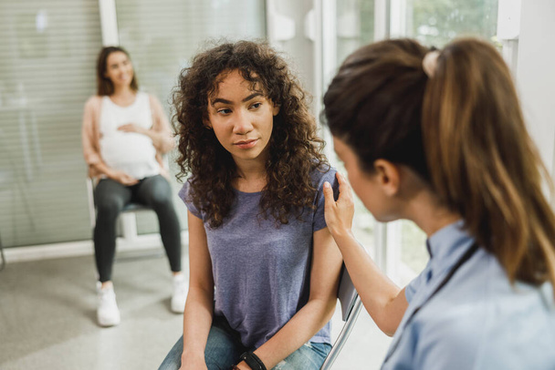 sconvolto afroamericano adolescente parla con infermiera mentre aspetta ginecologo check up. - Foto, immagini