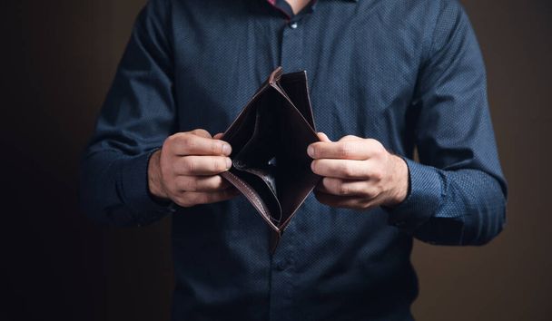 férfi bemutató üres pénztárca barna háttér - Fotó, kép