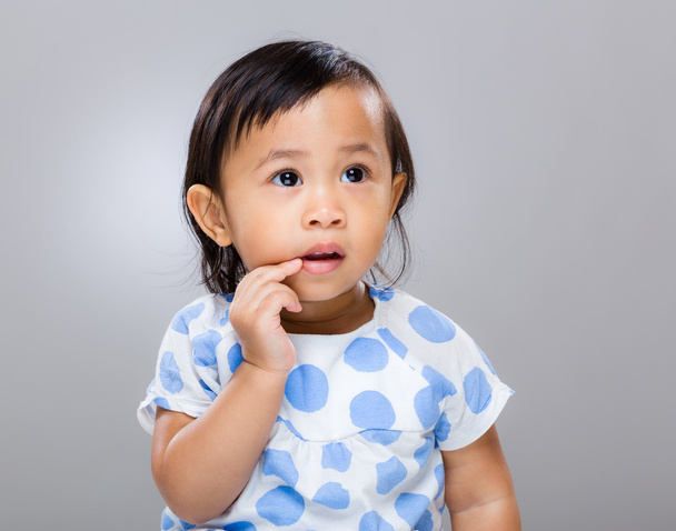 Дитяча дівчинка пальцем торкається рота
 - Фото, зображення
