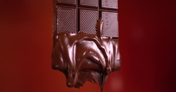 Batonik czekoladowy z rozpuszczoną czekoladą płynącą w zwolnionym tempie. Widok z bliska sfilmowany kamerą RED. - Materiał filmowy, wideo