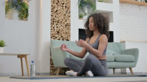 Mladá africká žena dělá meditaci na jógu Mat doma - Záběry, video