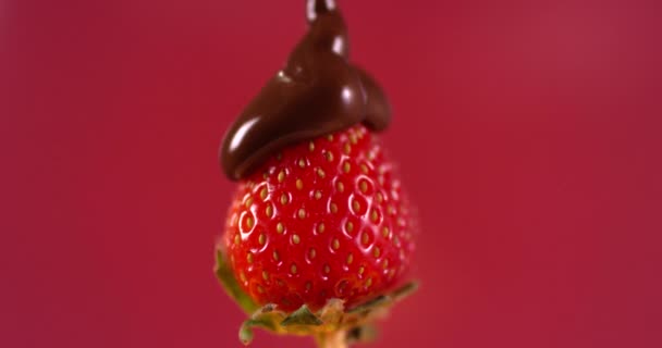 Geschmolzene Schokoladensauce, die auf frische Erdbeeren gegossen wird. Zeitlupe. Nahaufnahme gefilmt mit roter Kamera. - Filmmaterial, Video
