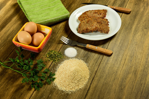 Vitela milanesa apresentada na mesa com ingredientes - Foto, Imagem