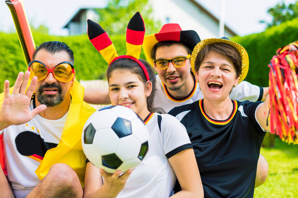 happy family cheering for the German soccer team outside in the garden - Foto, imagen