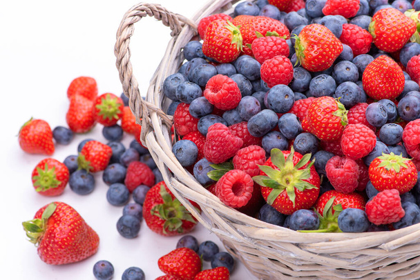 Basket with berries. Raspberries, strawberries and blueberries. Isolate - Photo, Image