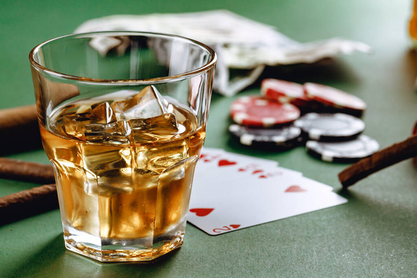 Glass of whiskey, cigar, playing cards and chips on green background - Photo, Image