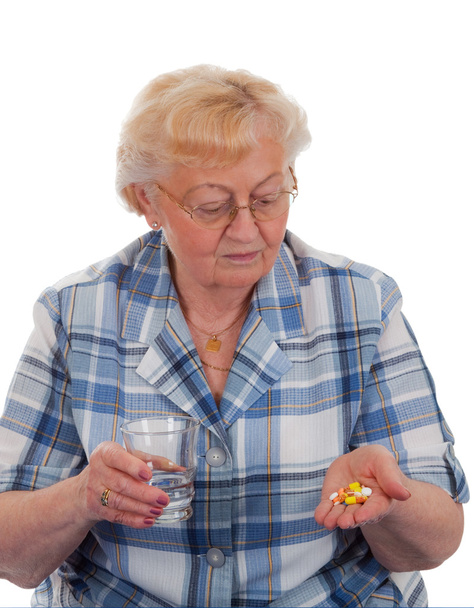 starsza kobieta, patrząc na jej rękę z tabletki - na białym tle - Zdjęcie, obraz