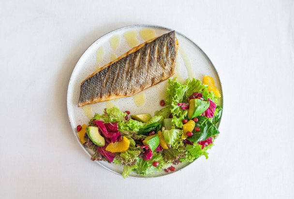 dish grilled fish with vegetables avocado salad spinach orange and pomegranate seed - Photo, Image