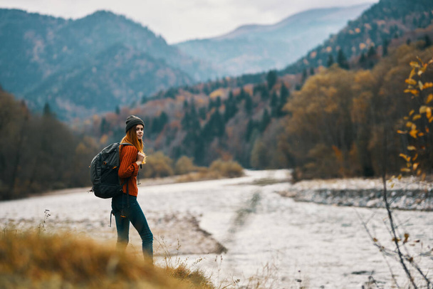 mujer con mochila senderismo por el río en el paisaje de las montañas - Foto, Imagen