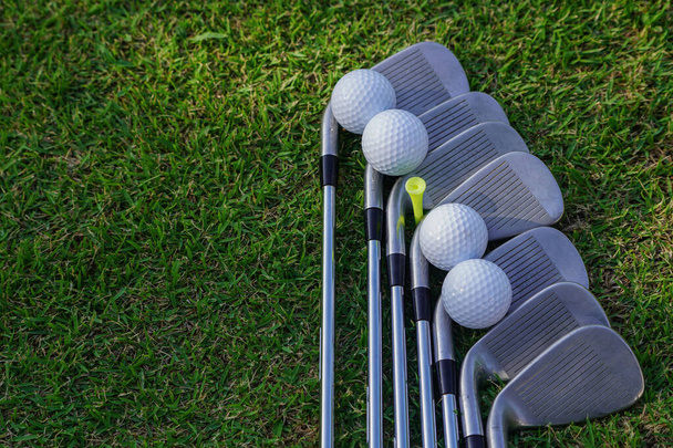 Golf equipment. Golf ball and golf club on green grass background. Collection of golf equipment resting on green grass. Outdoor sport.                                 - Foto, imagen